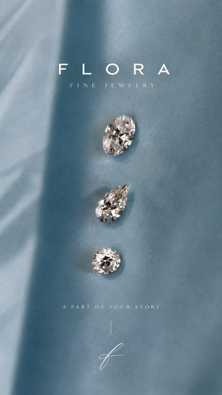 Loose oval, pear and round diamonds on petrol-blue satin under the FLORA Fine Jewelry wordmark