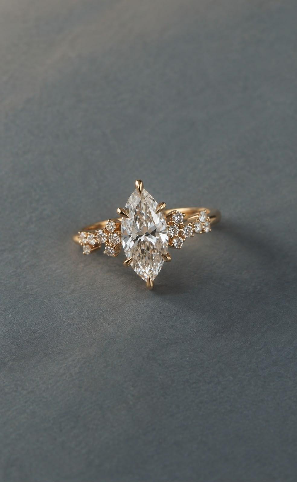 ANDËRR Ring: yellow gold marquise diamond with clusters of small diamonds on the shoulders, on slate grey