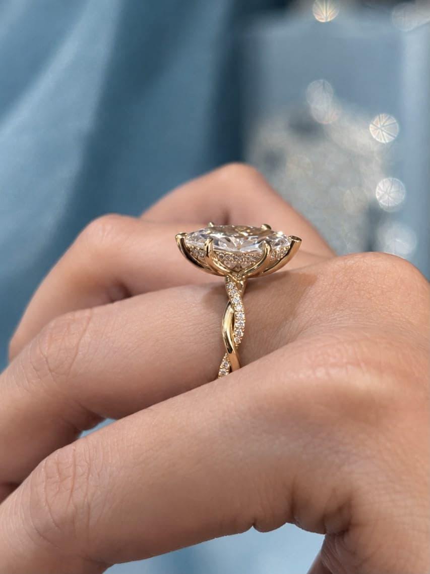 The Marquise worn on a hand, showing the twisted pavé band from the side