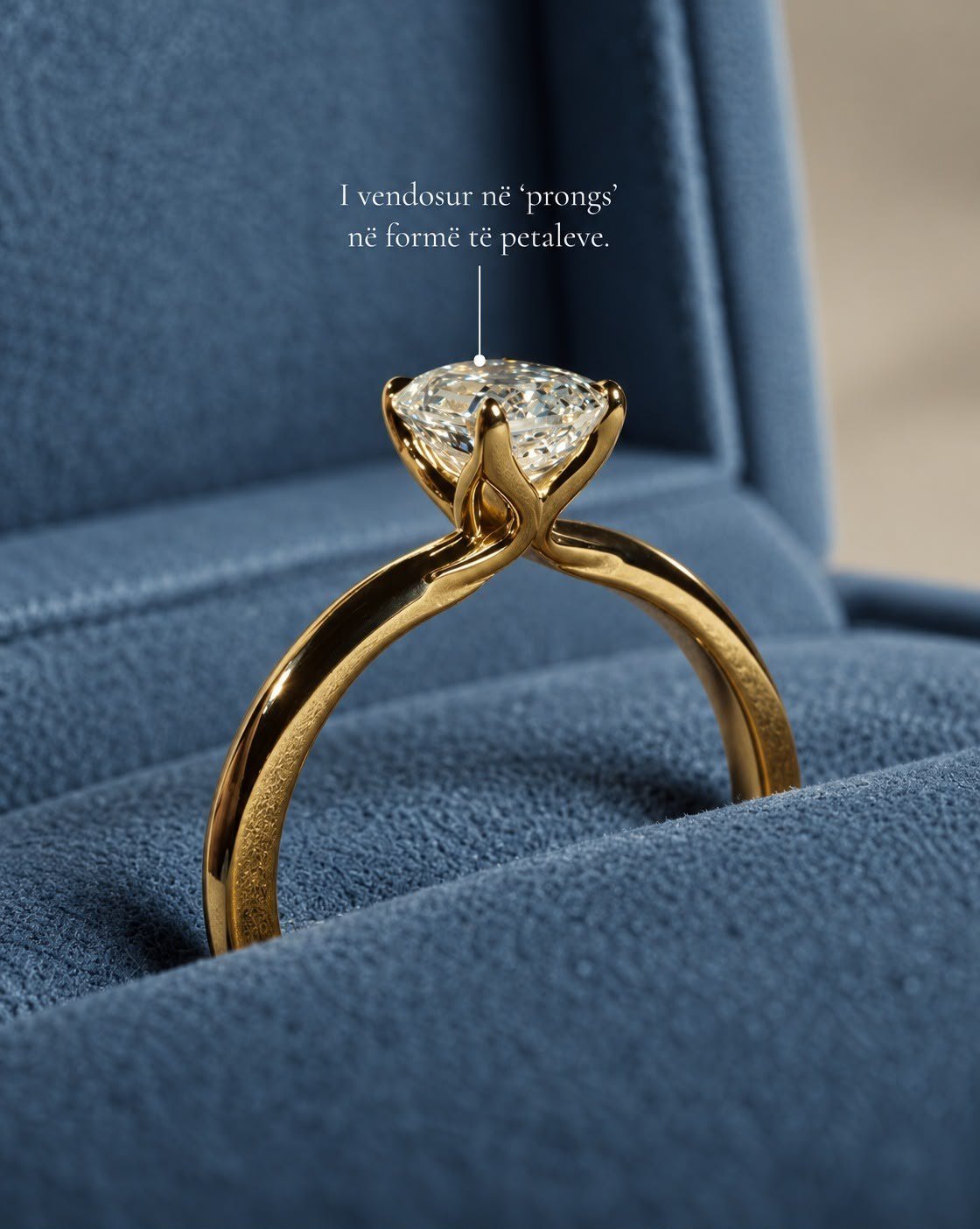 Yellow gold solitaire with petal-shaped prongs in a denim-blue velvet box