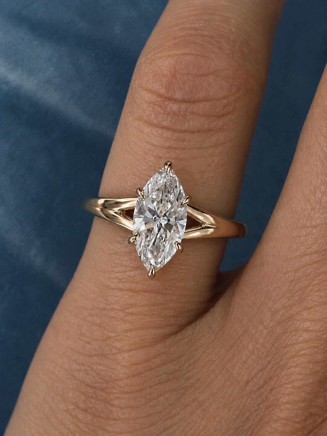 Marquise diamond solitaire on a yellow gold split shank, worn on a finger