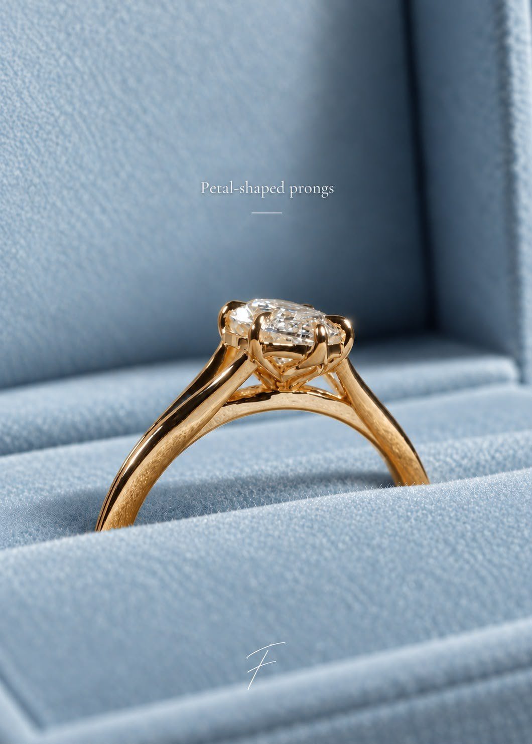 Side profile of the solitaire in a powder-blue box, showing petal-shaped prongs