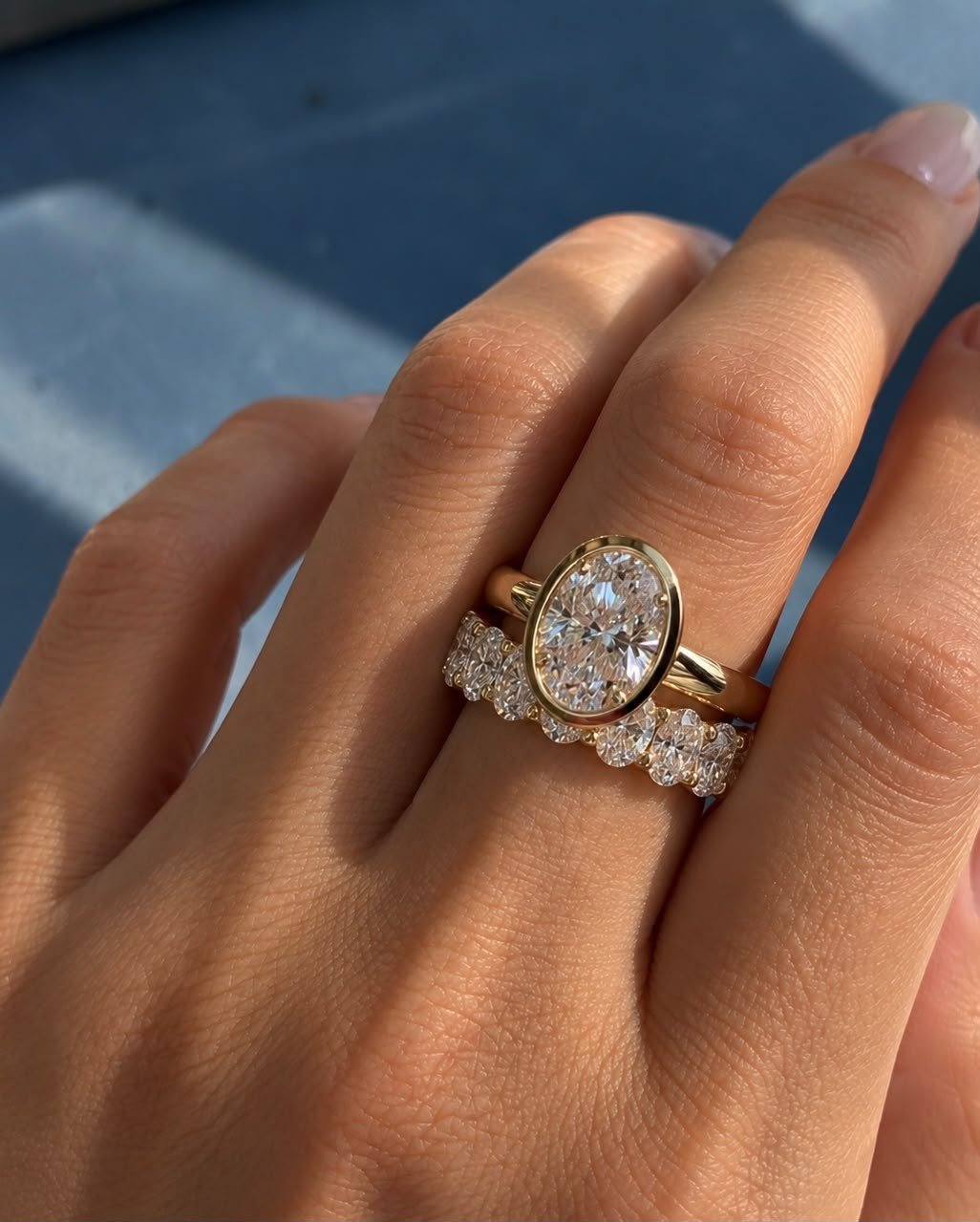 Oval bezel ring and oval eternity band worn together on a hand