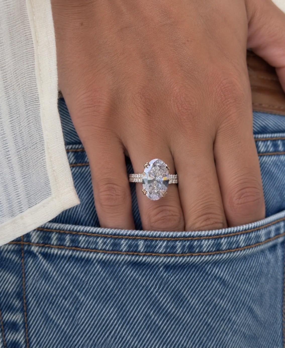 DRITË oval diamond ring on a hand resting in a denim pocket