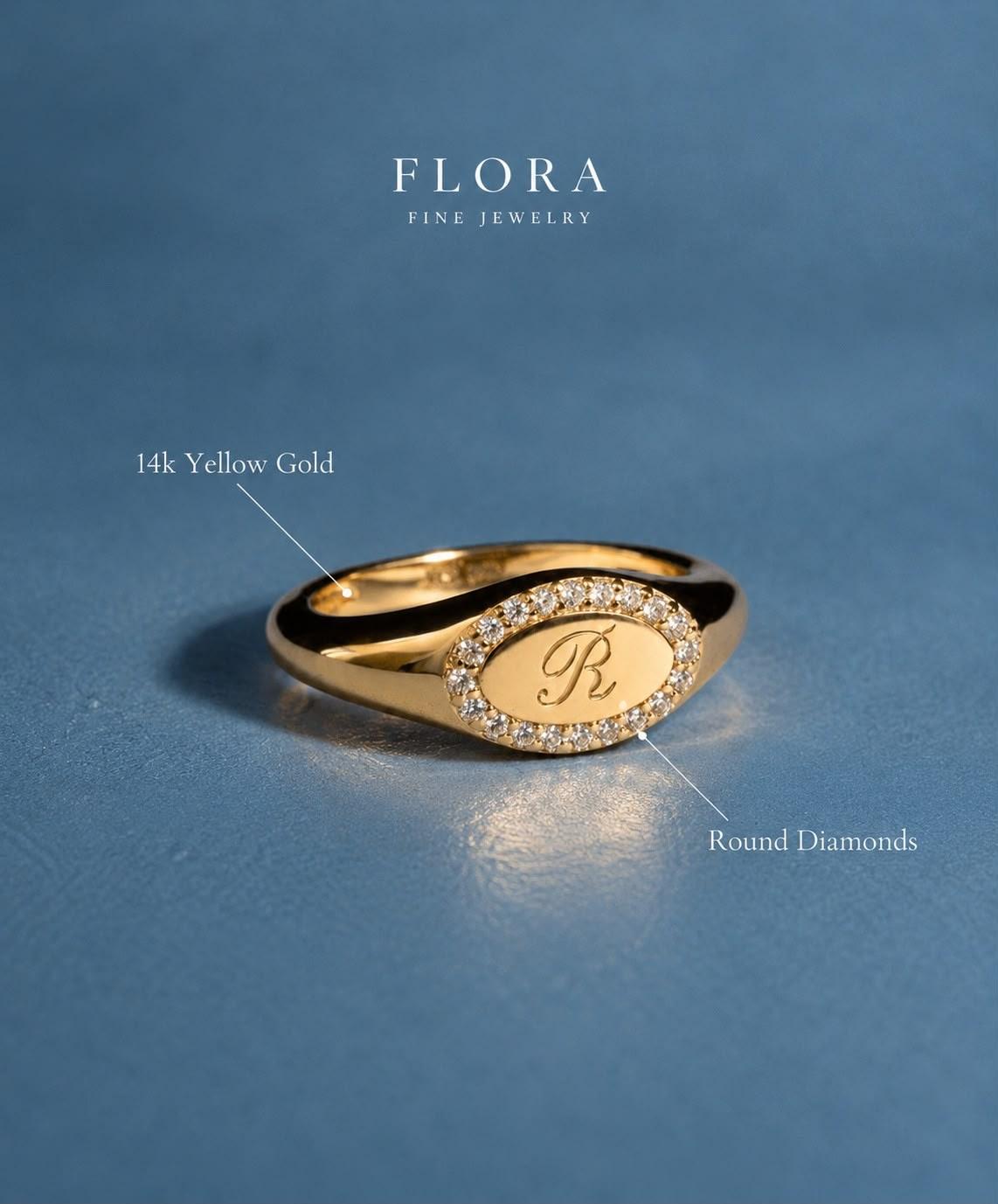 14k yellow gold oval signet ring engraved with a script R inside a halo of round diamonds